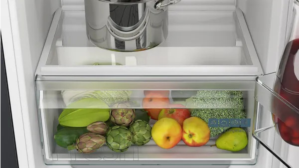 In een koelkastlade vol groenten en een pot.