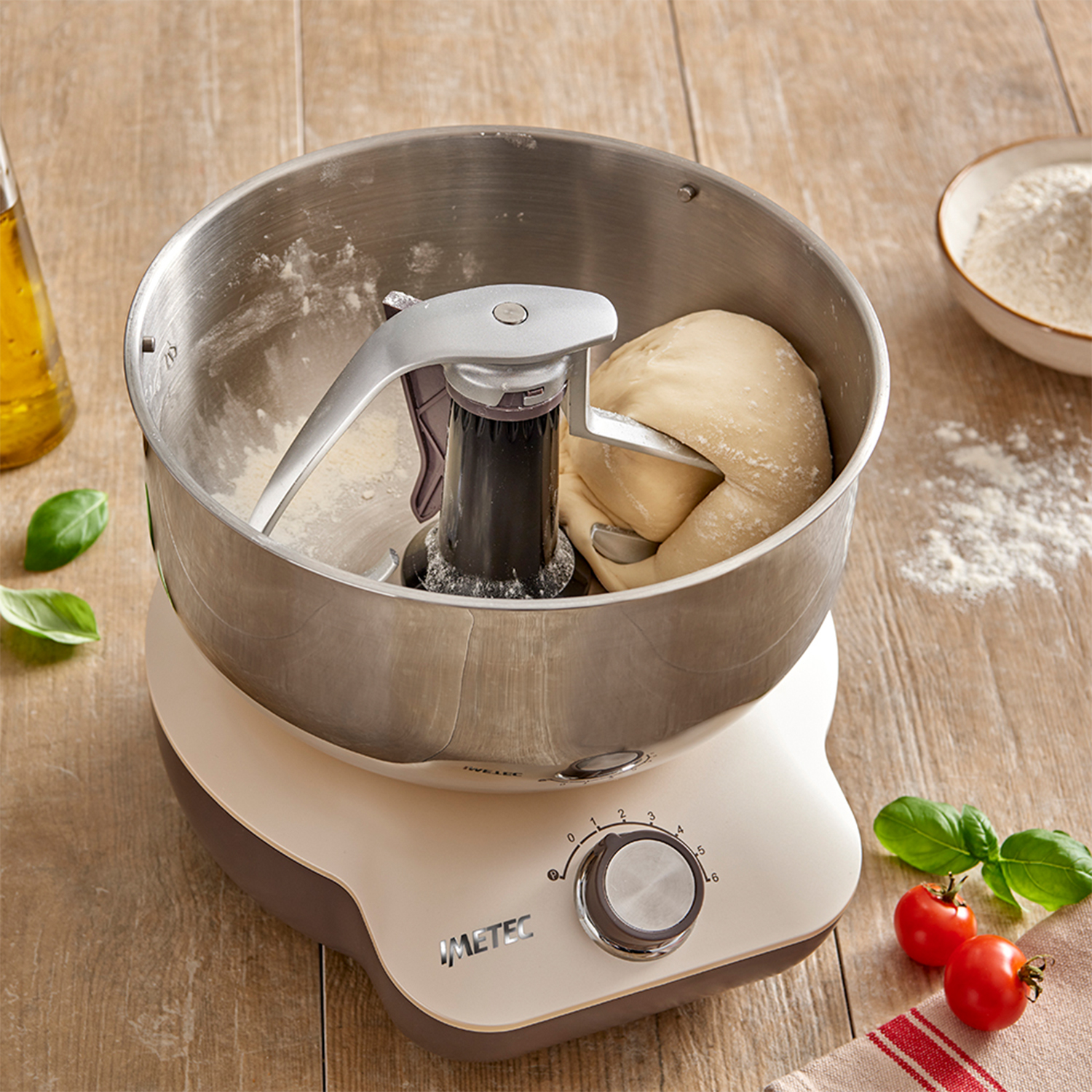 Un mixer con impasto all'interno, con pomodori e basilico.