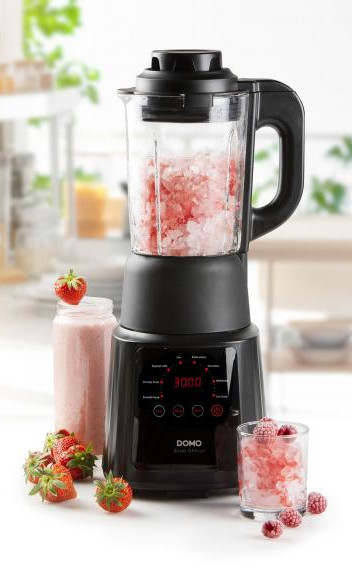 A blender with pink ice and strawberries, showing a smoothie preparation scene.