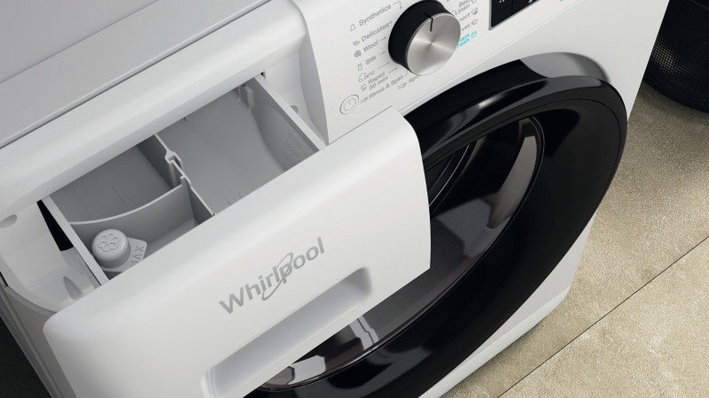 Fehér Whirlpool mosógép fiókja, nyitva. Fehér belső terek rekeszekkel és adagolóval.