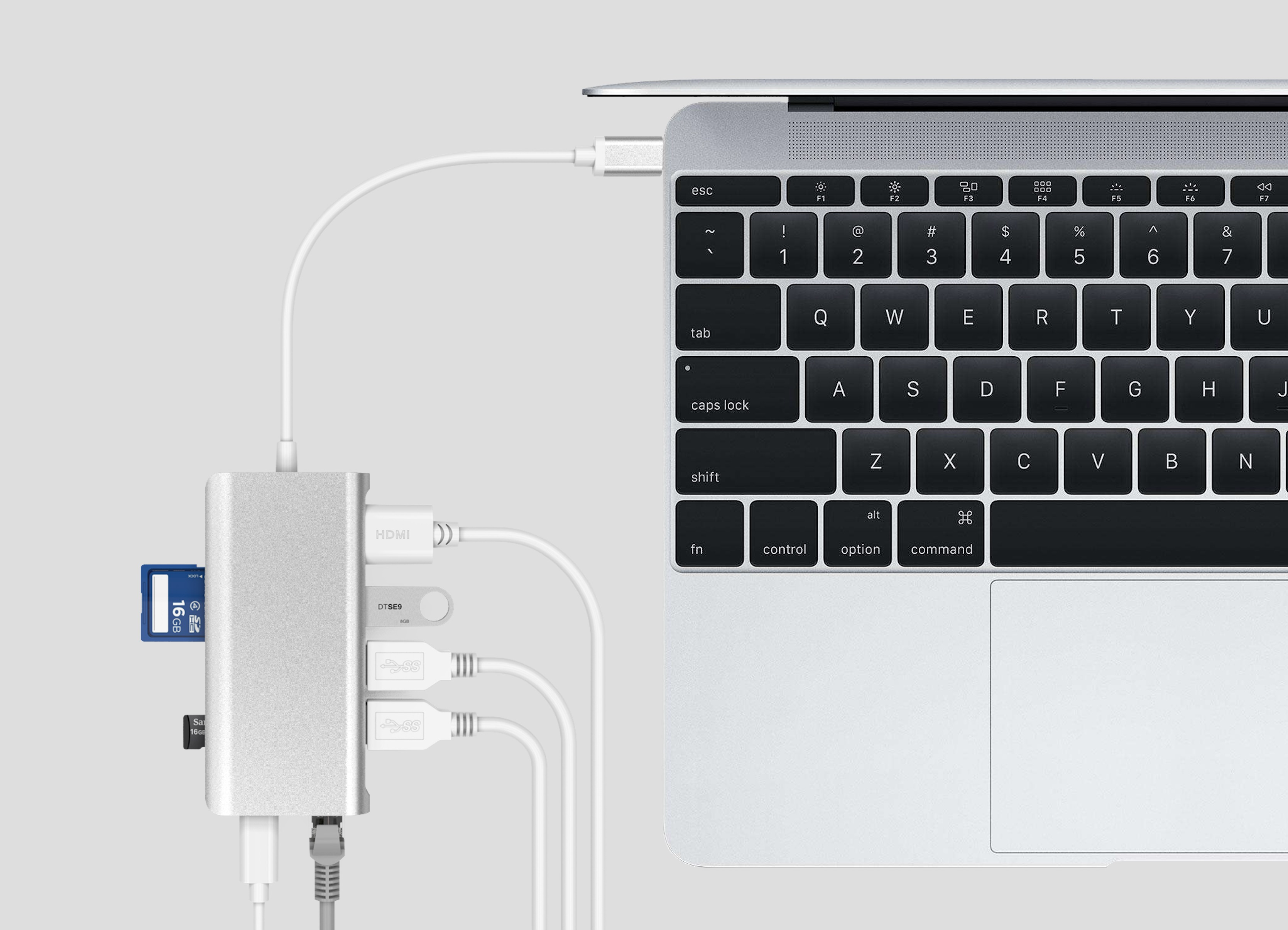 Laptop, verbunden mit einem silbernen Hub mit mehreren Anschlüssen und einer SD-Karte.