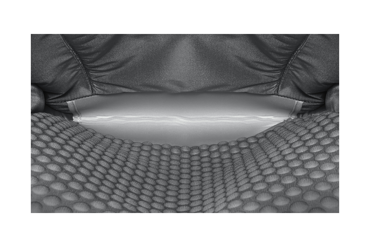 Primer plano de una silla gris con asiento texturizado y respaldo parcialmente visible.