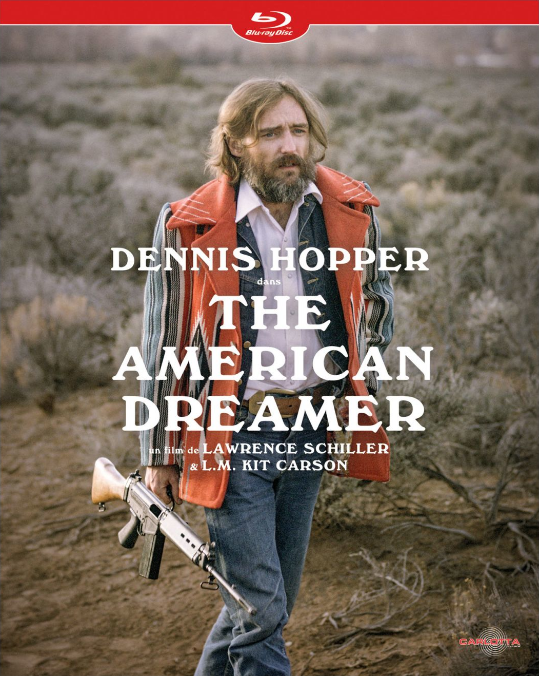 Affiche du film The American Dreamer, avec Dennis Hopper tenant un fusil, scène en extérieur.