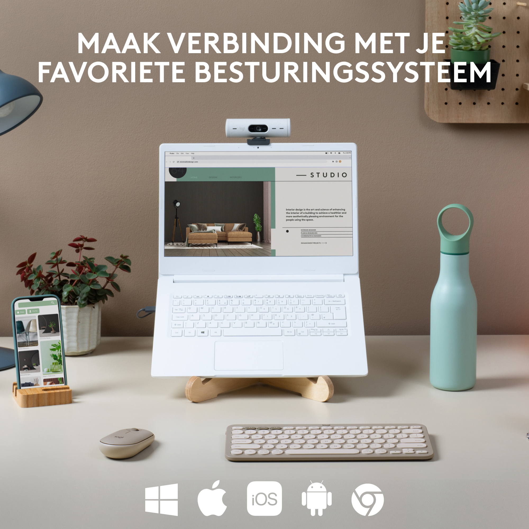 Een witte laptop met webcam, telefoon, toetsenbord, muis en waterfles, op een bureau.