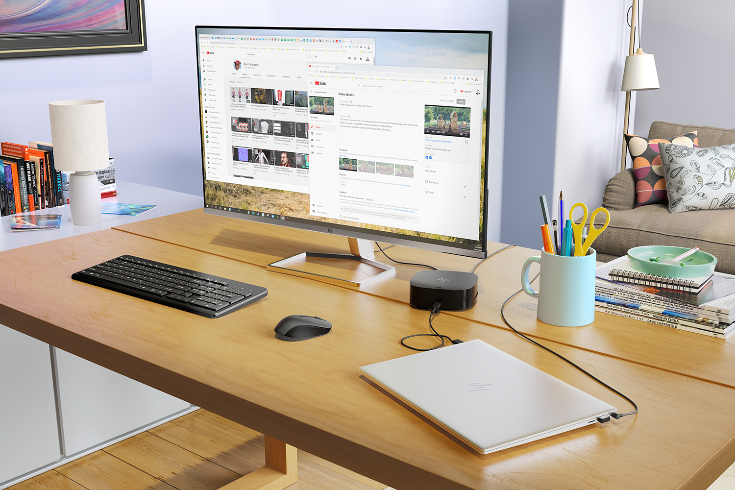 Een computeropstelling op een houten bureau met een monitor, toetsenbord, muis en laptop.