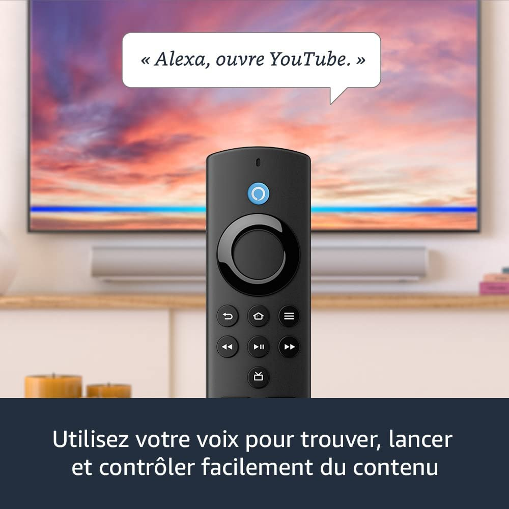 Télécommande Amazon Fire TV noire en main, avec une TV affichant un coucher de soleil.