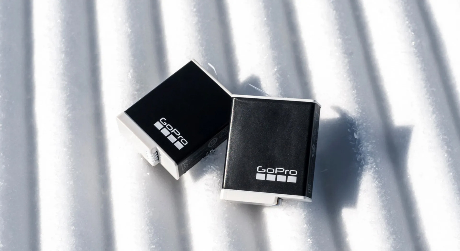 Deux batteries GoPro noires sur une surface blanche texturée. Le logo GoPro est visible sur chaque batterie.