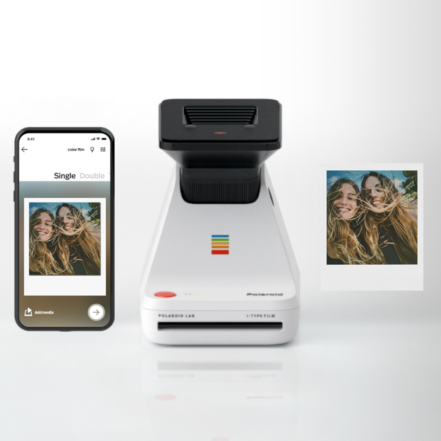 Een wit Polaroid Lab-apparaat met een foto en een telefoon die een foto van twee vrouwen toont.