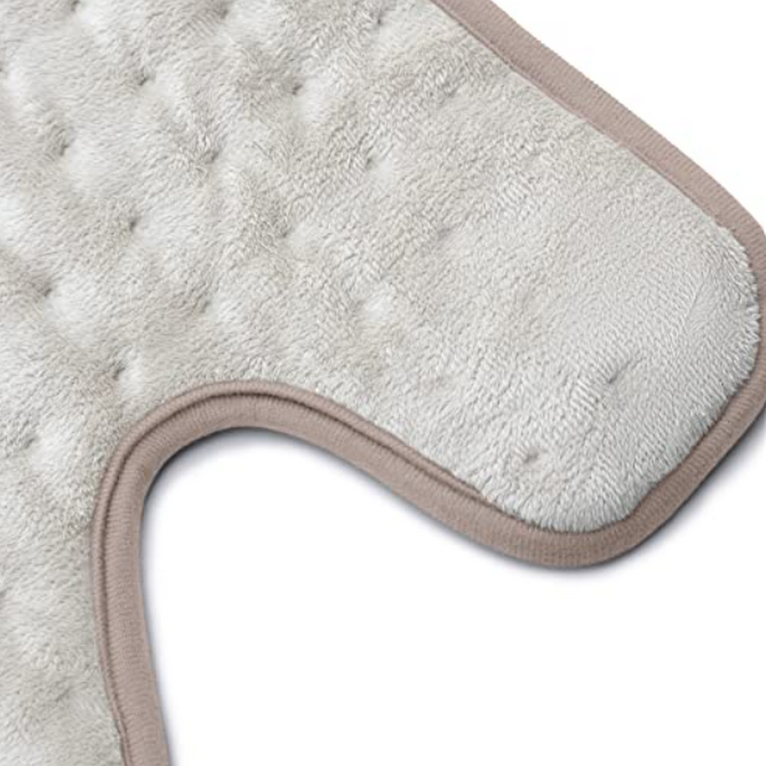 Primer plano de una almohadilla térmica blanca con borde beige, mostrando su superficie texturizada.
