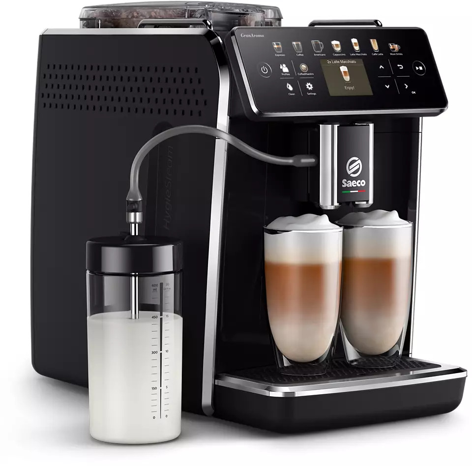 Zwarte koffiemachine met twee glazen latte macchiato en een melkcontainer.
