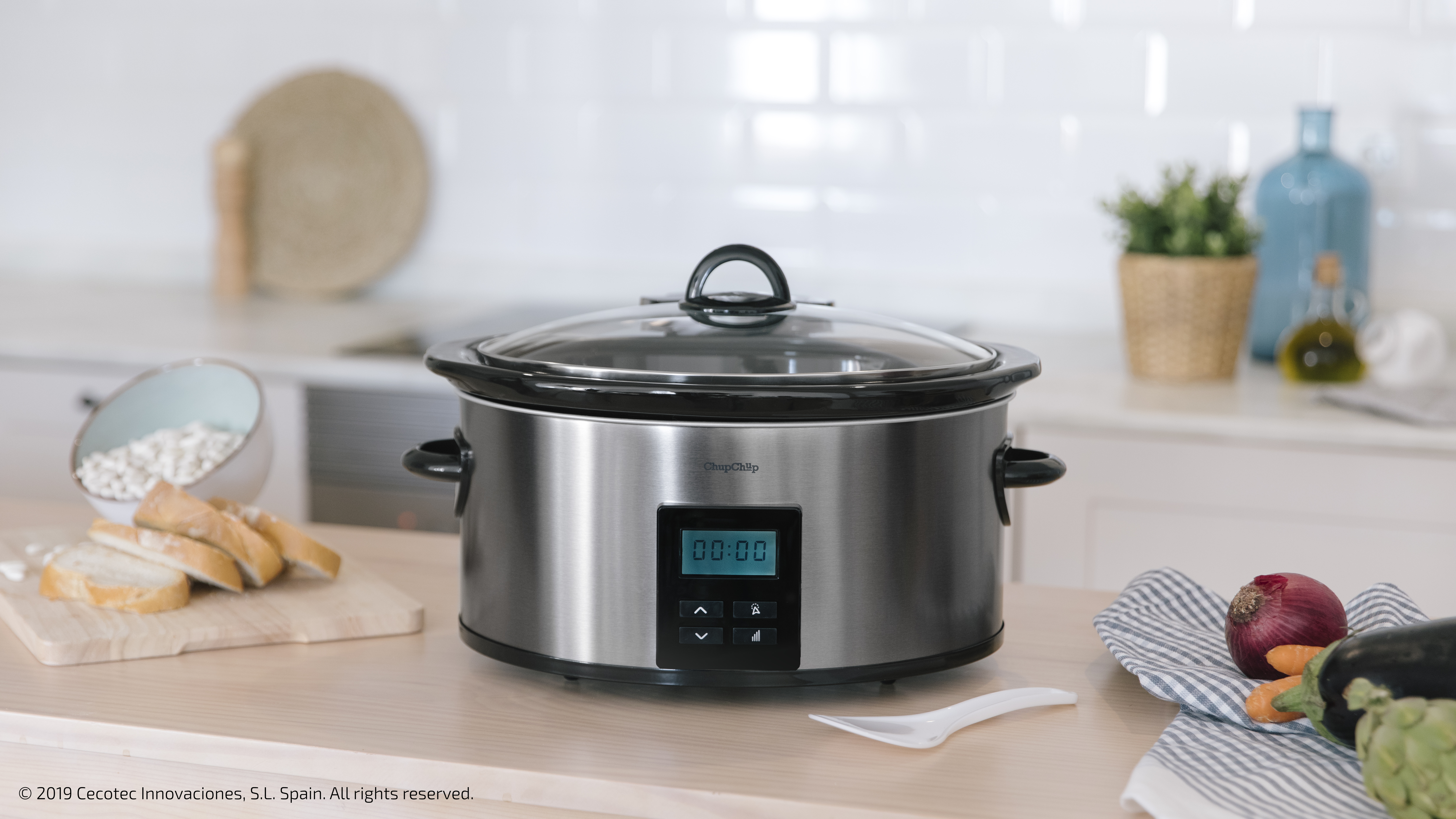 Una olla de cocción lenta de acero inoxidable en una encimera con tapa. Ambiente de cocina.