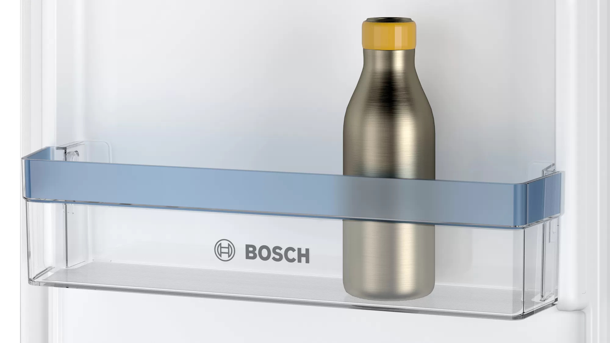Une bouteille à l'intérieur d'un réfrigérateur. Elle est sur une étagère avec un logo BOSCH.