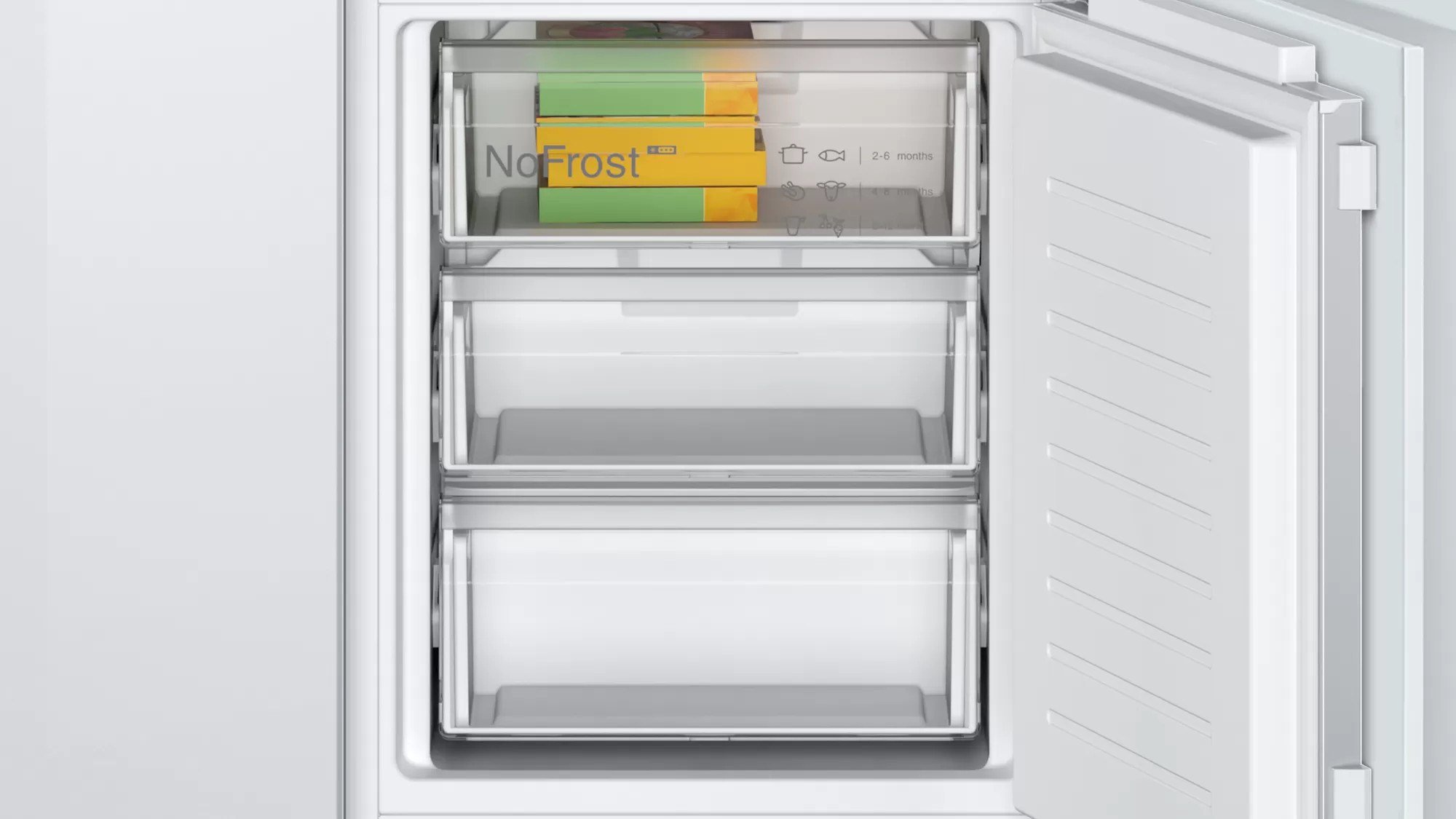 Intérieur de réfrigérateur avec tiroirs, contenant des aliments surgelés.