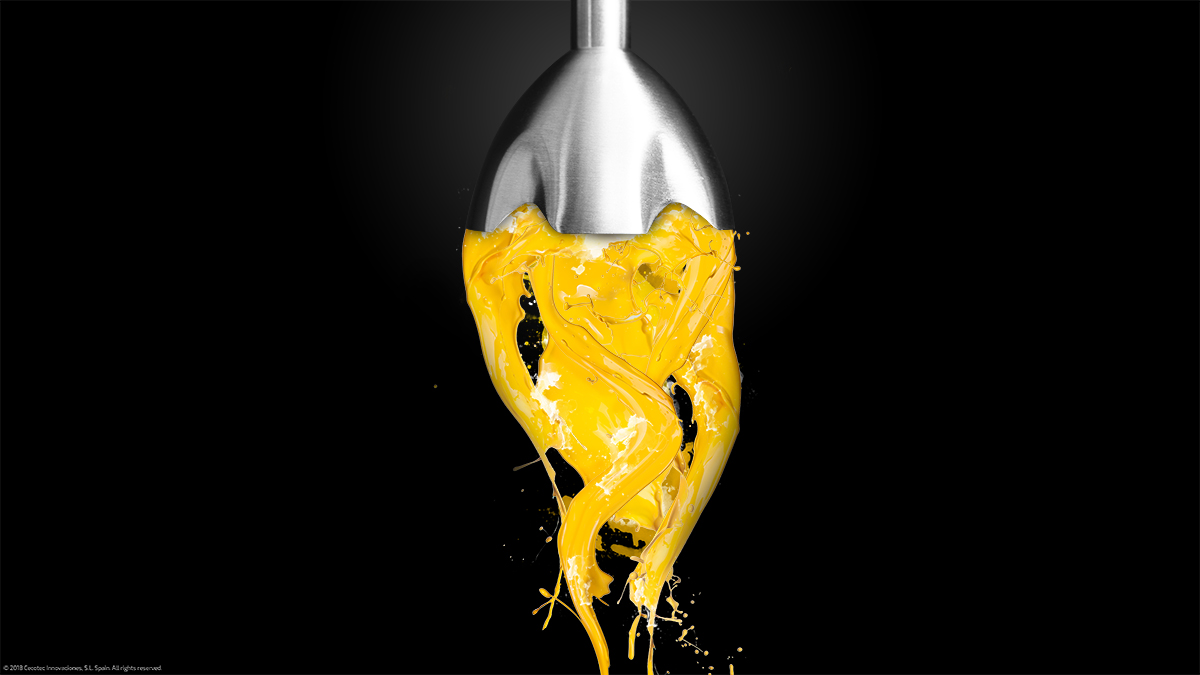 Una licuadora con líquido amarillo salpicando, contra un fondo negro.