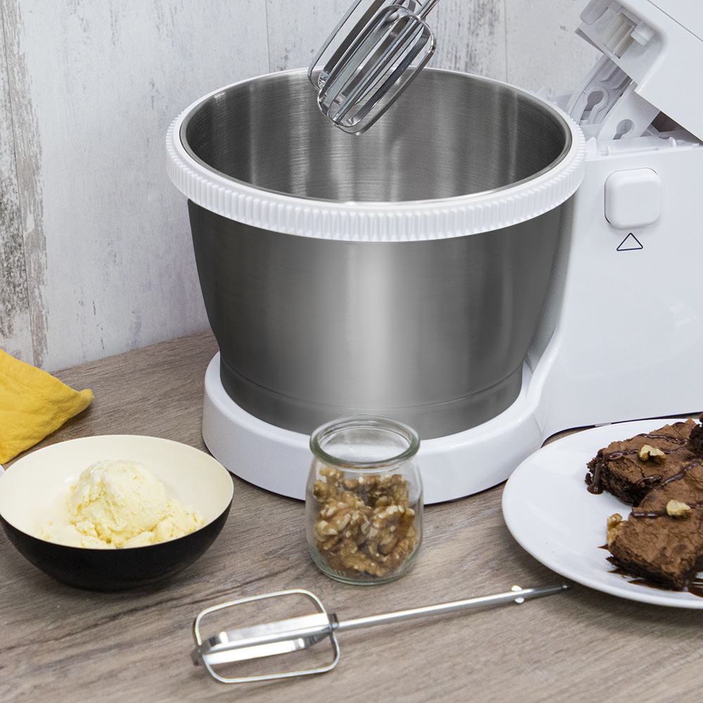 Un bol mezclador con batidora, un bol de helado, un tarro de nueces y brownies.