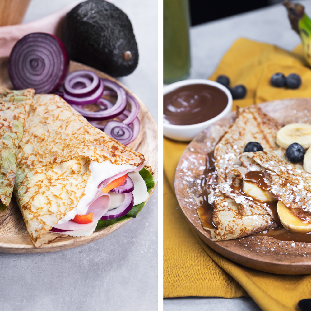 Crepes con rellenos, uno con jamón y cebolla roja, el otro con plátanos y chocolate, en platos de madera.