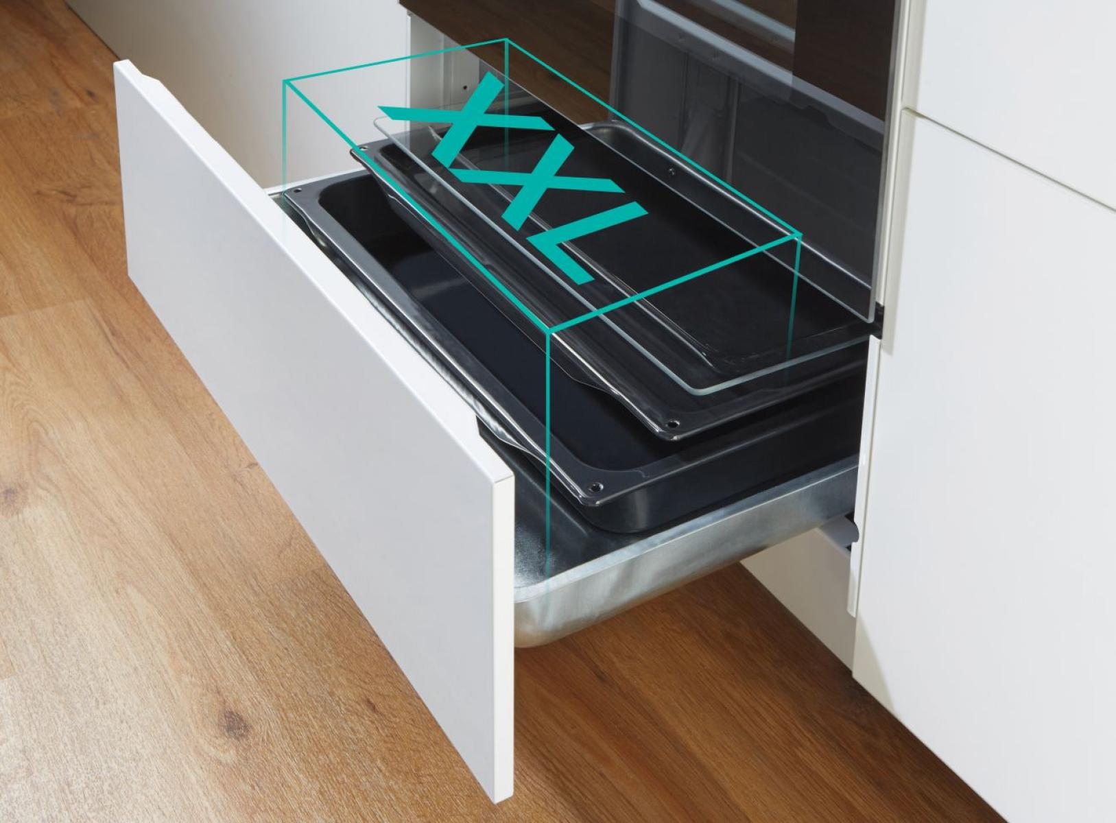 Eine Schublade, die aus einem Schrank gezogen wurde. Zwei Tabletts sind darin, mit dem Wort XXL darüber. Holzfußboden.
