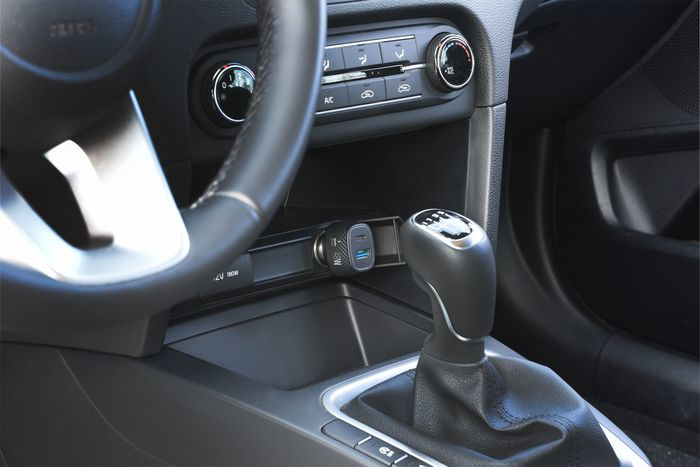 Interior de un coche: volante, palanca de cambios y consola central con ventilación, botones y cargador USB.