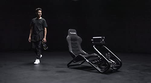 Un hombre camina hacia una silla gamer. El fondo es oscuro.