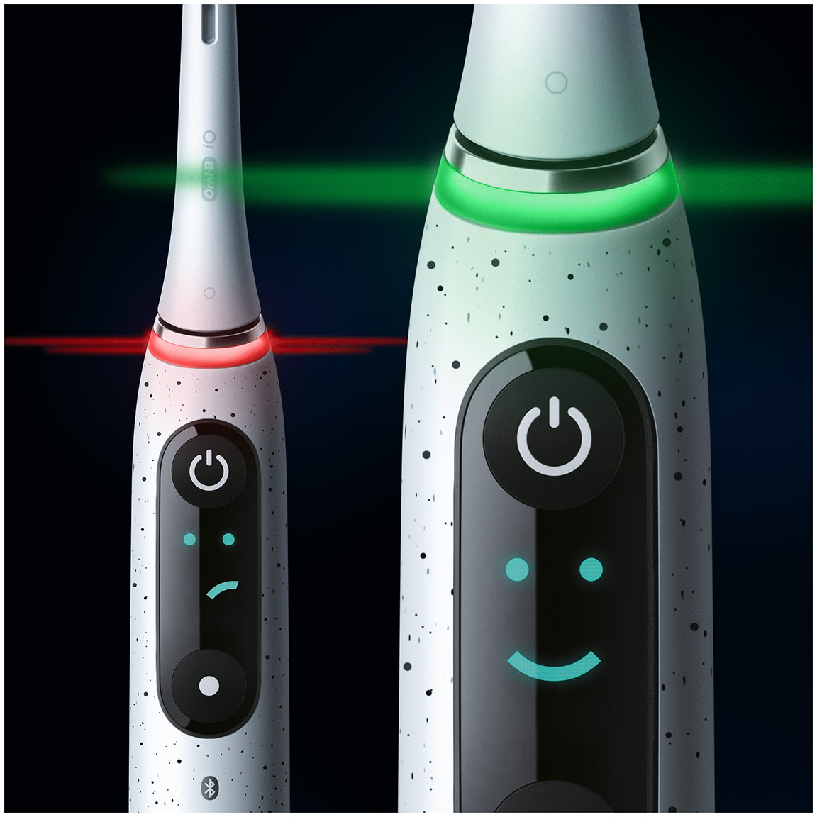Deux brosses à dents électriques : une avec une lumière rouge, une avec une lumière verte et un visage souriant affiché.