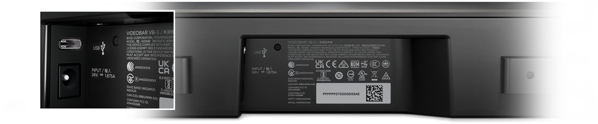 Fekete eszköz hátsó panelje portokkal és címkékkel, USB és bemenet.