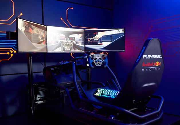 Un simulador de carreras con tres monitores y un asiento Red Bull Racing en una habitación iluminada en azul.