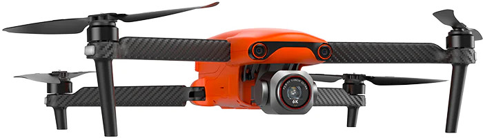 Drone orange avec des hélices et un train d'atterrissage noirs. Il possède une caméra montée à l'avant.