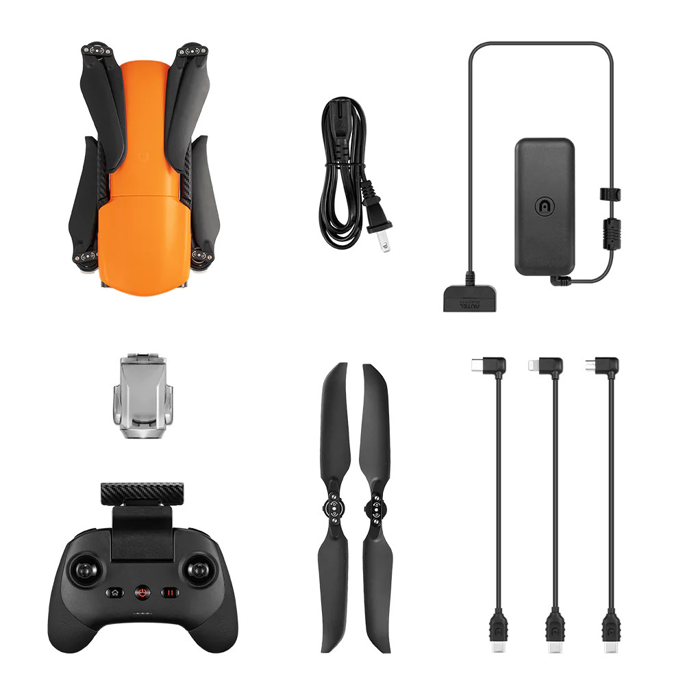 Drone orange avec accessoires, dont télécommande, câbles et chargeur.