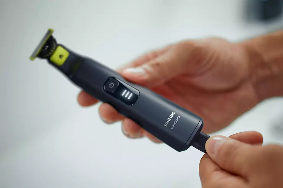 Man met een zwarte en limoengroene Philips OneBlade trimmer.