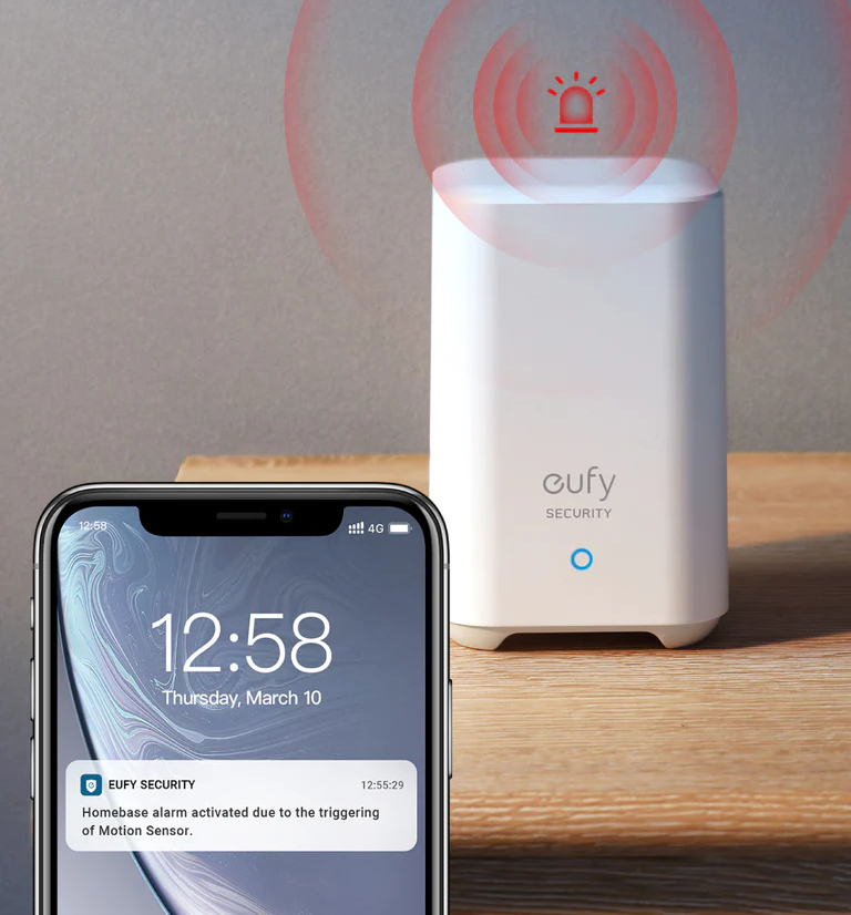 Eufy beveiligingssysteem met telefoon die een melding toont op houten tafel.