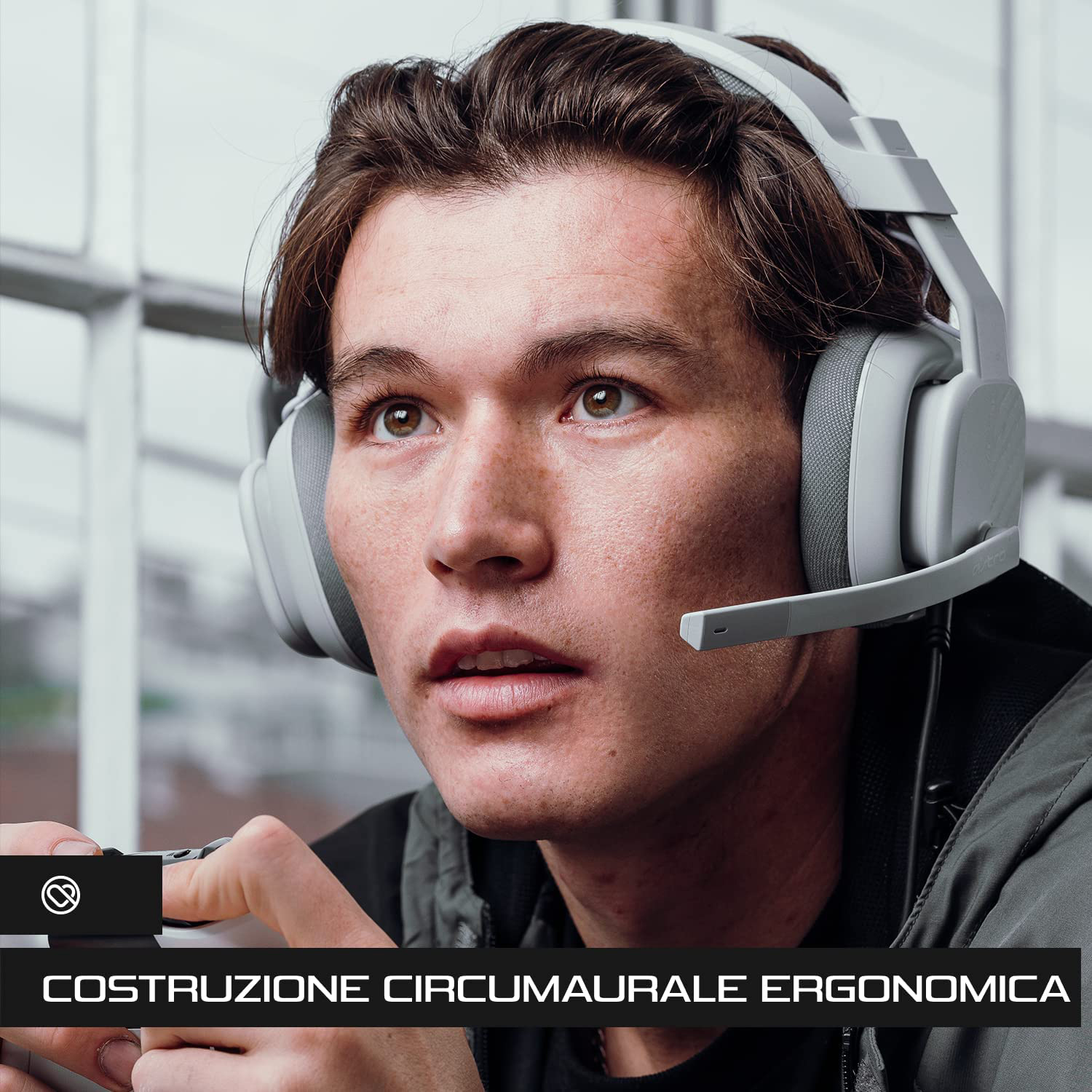 Un uomo che indossa le cuffie e tiene in mano un controller di gioco.