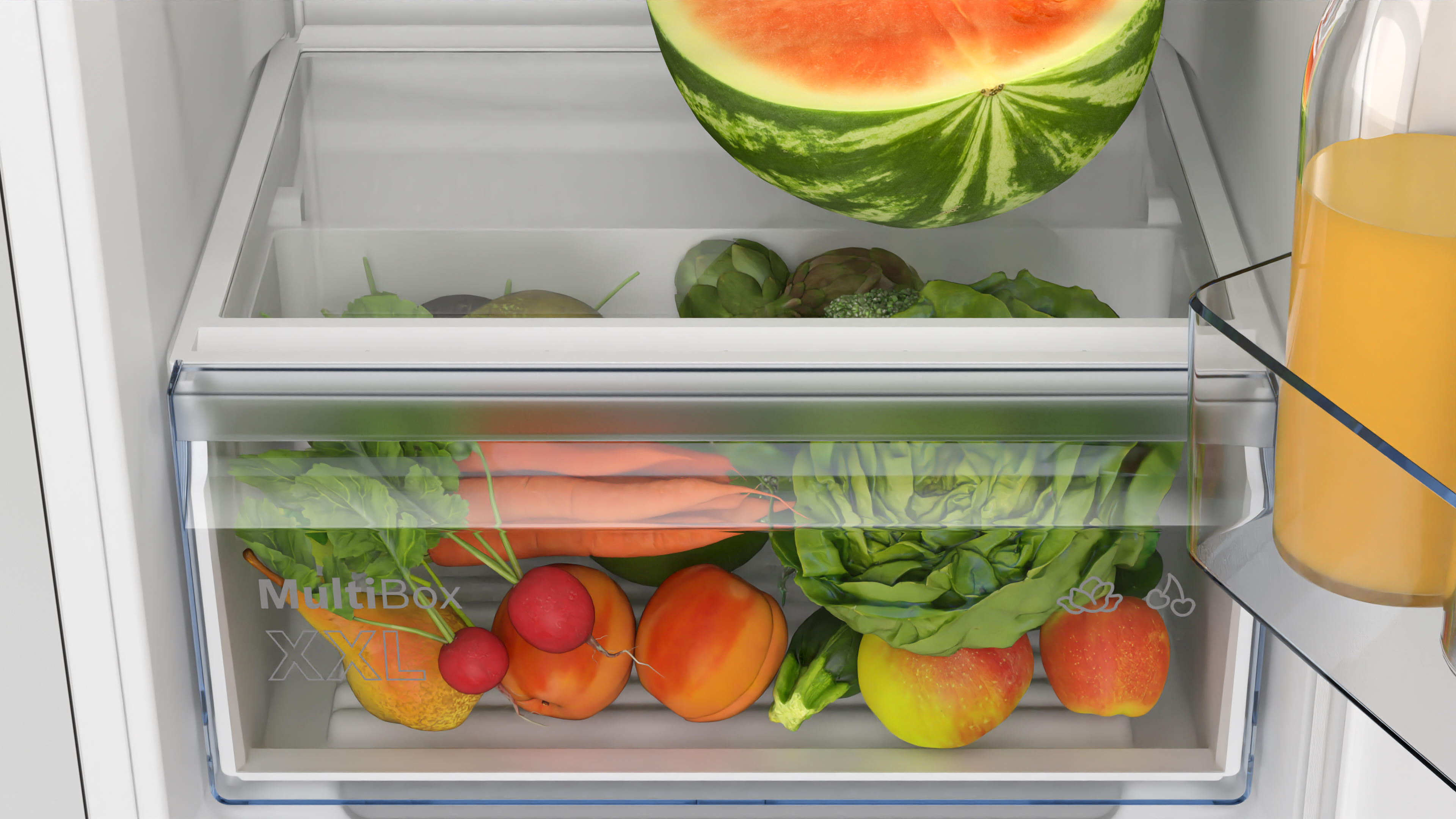 Refrigerator drawer filled with vegetables and fruits. Contains lettuce, carrots, apples, etc.