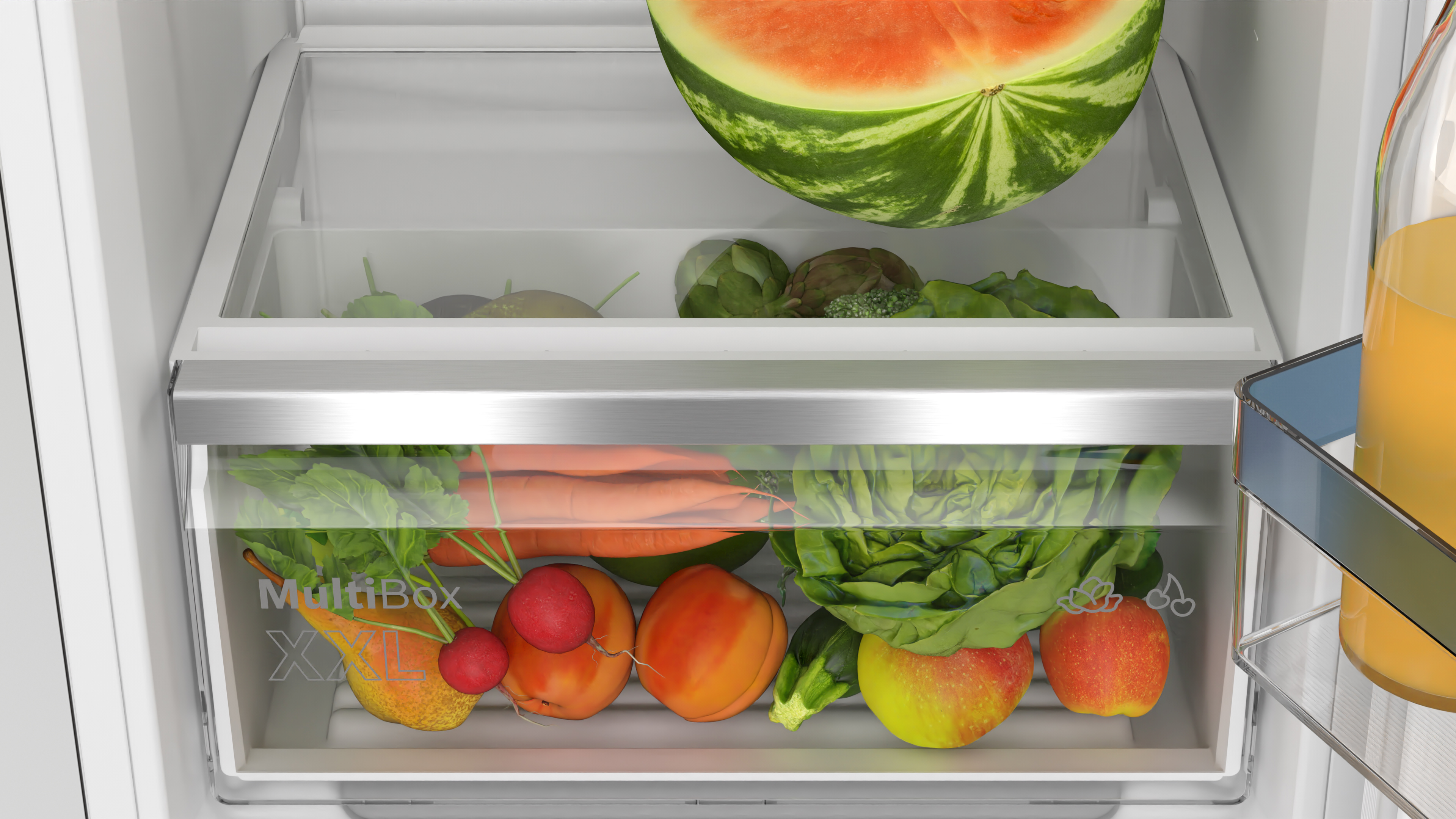 Refrigerator interior with a drawer filled with fruits and vegetables.