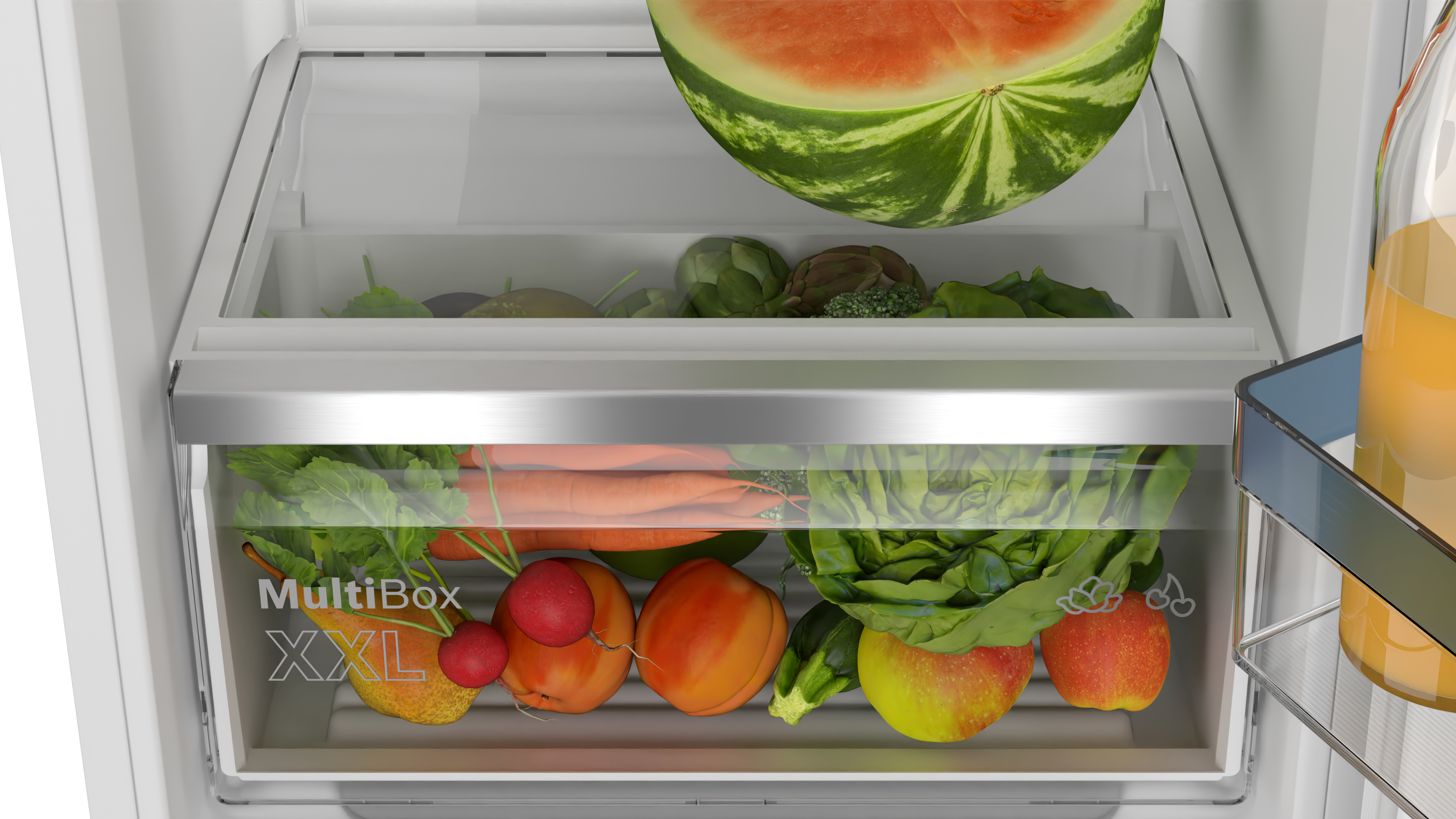 A refrigerator drawer filled with vegetables and a watermelon.