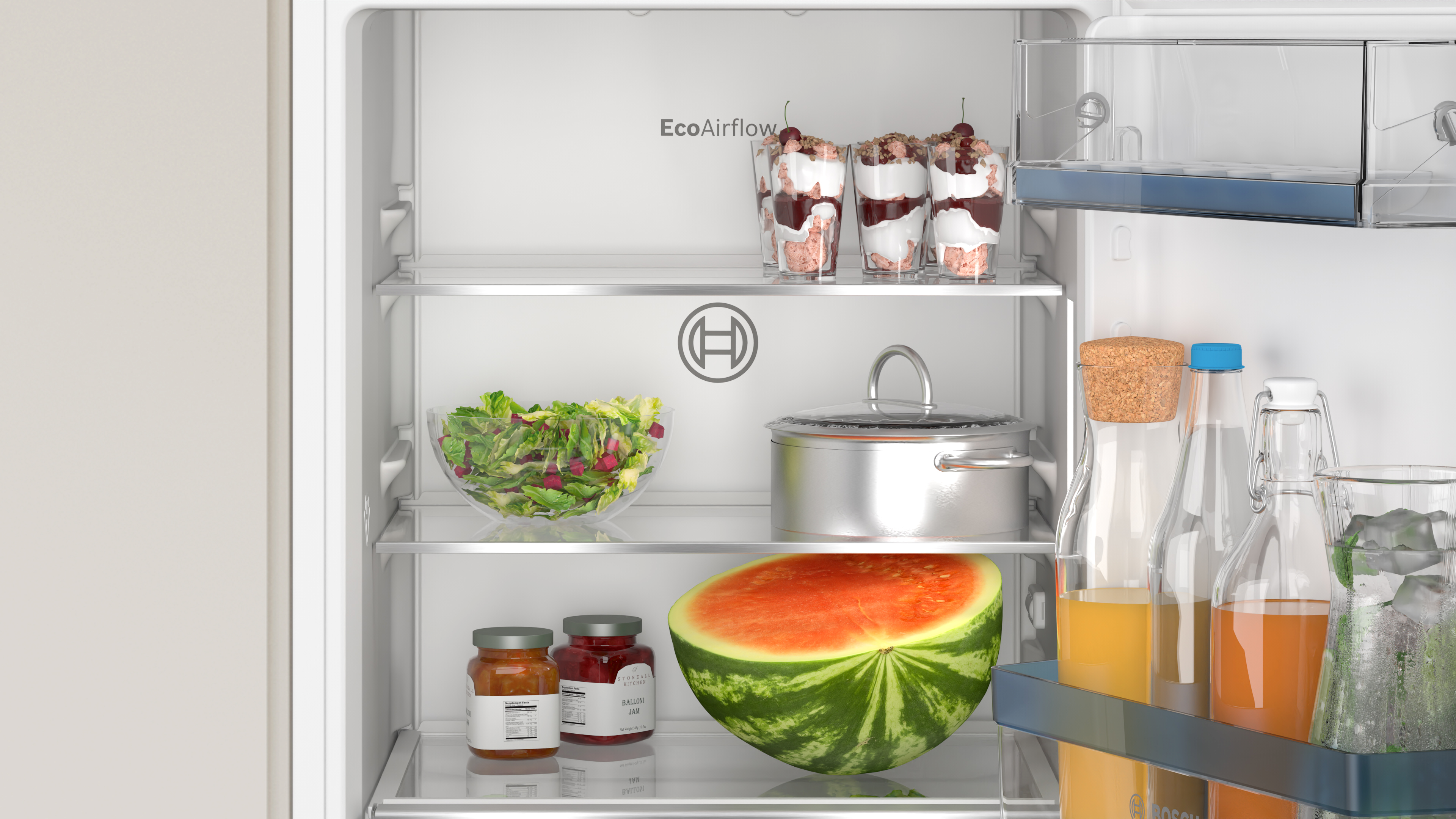 Inside a refrigerator. Salad, jars, watermelons, and desserts in glasses are visible on shelves.