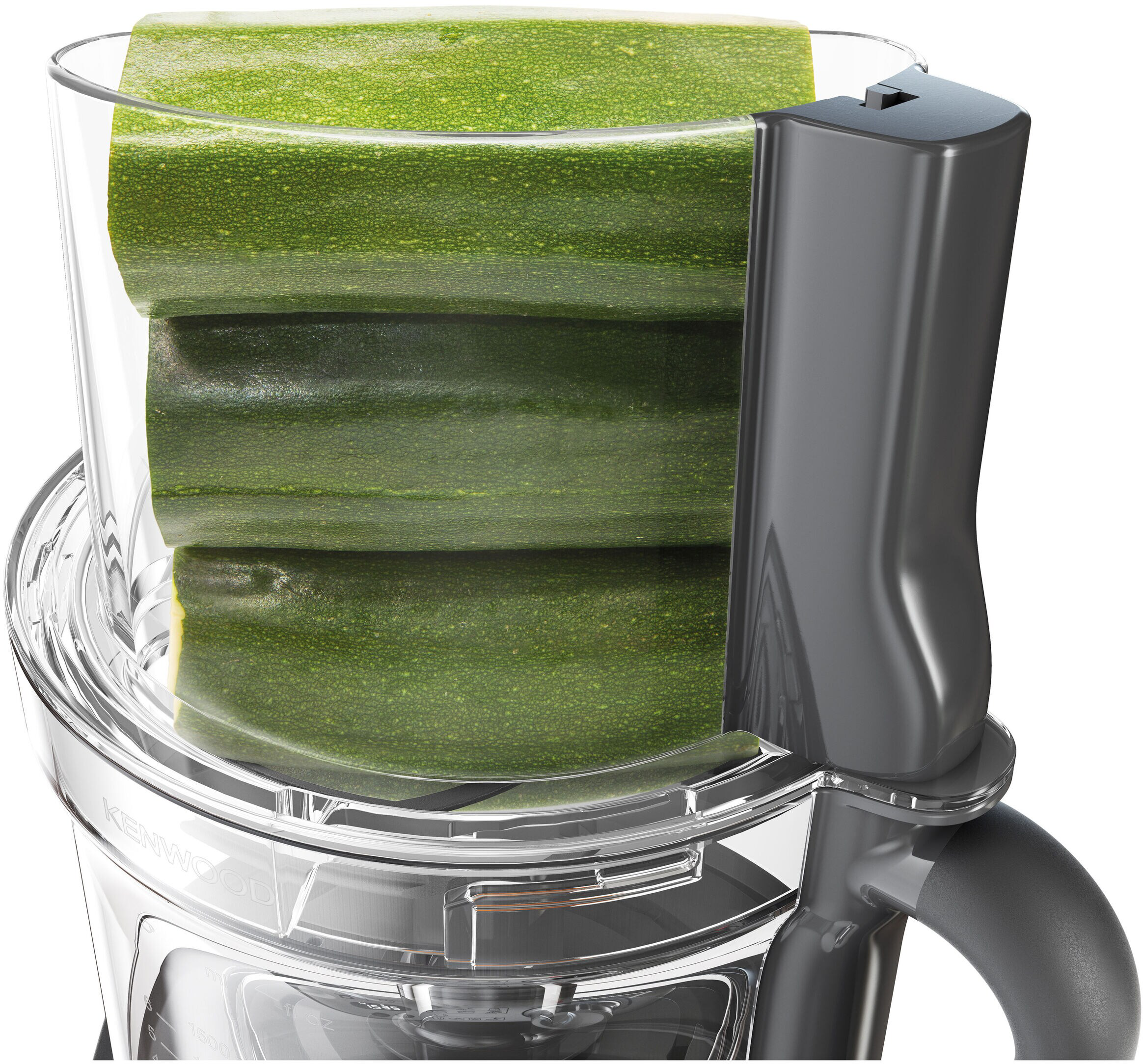 Una ciotola di un robot da cucina riempita con tre zucchine verdi.