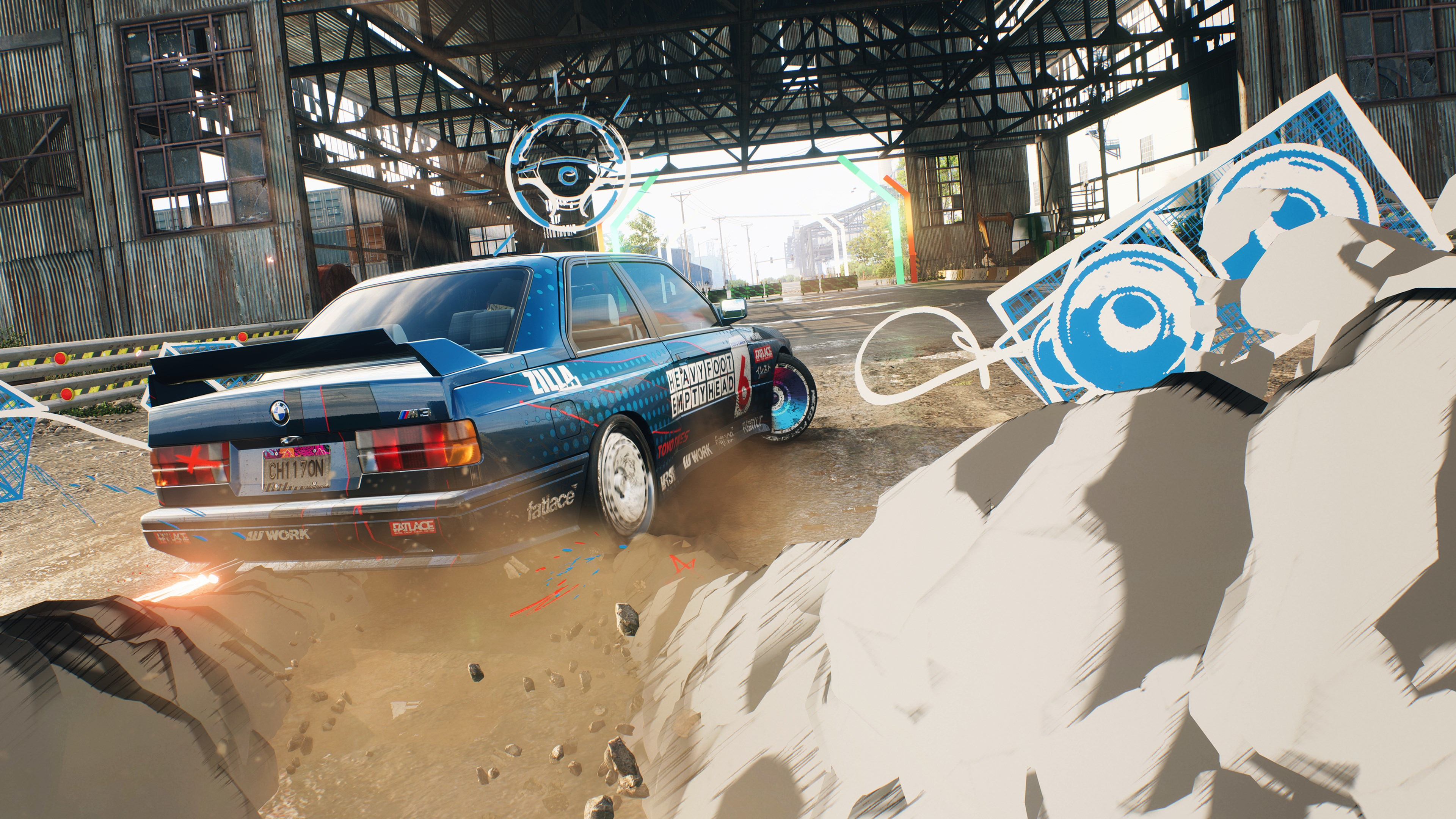 Blaues Rennauto, das auf einer Dirt-Strecke driftet, in der Nähe eines Garageneingangs.