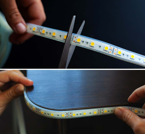 Schere schneidet einen LED-Streifen und ein Abschnitt des LED-Streifens, der auf einem Tisch installiert ist.