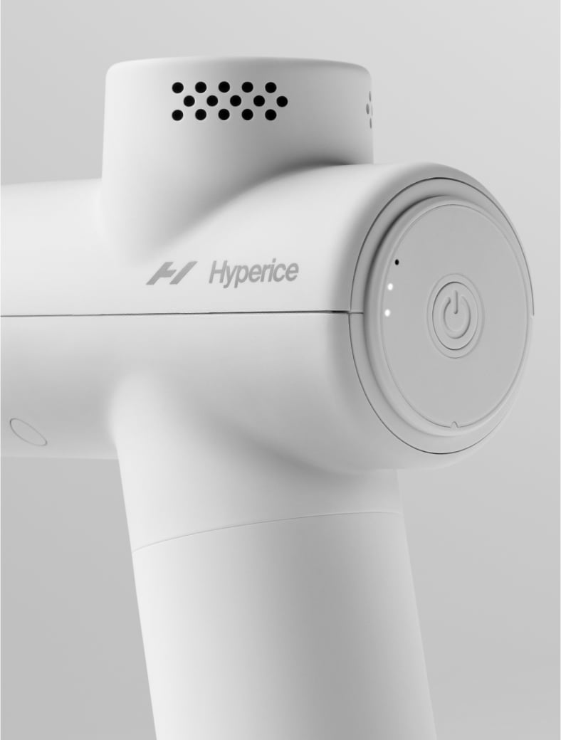 Egy fehér masszázspisztoly közelképe, a 'Hyperice' márkanévvel.