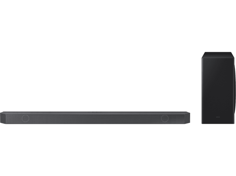 Barra de sonido negra y subwoofer sobre un fondo negro.