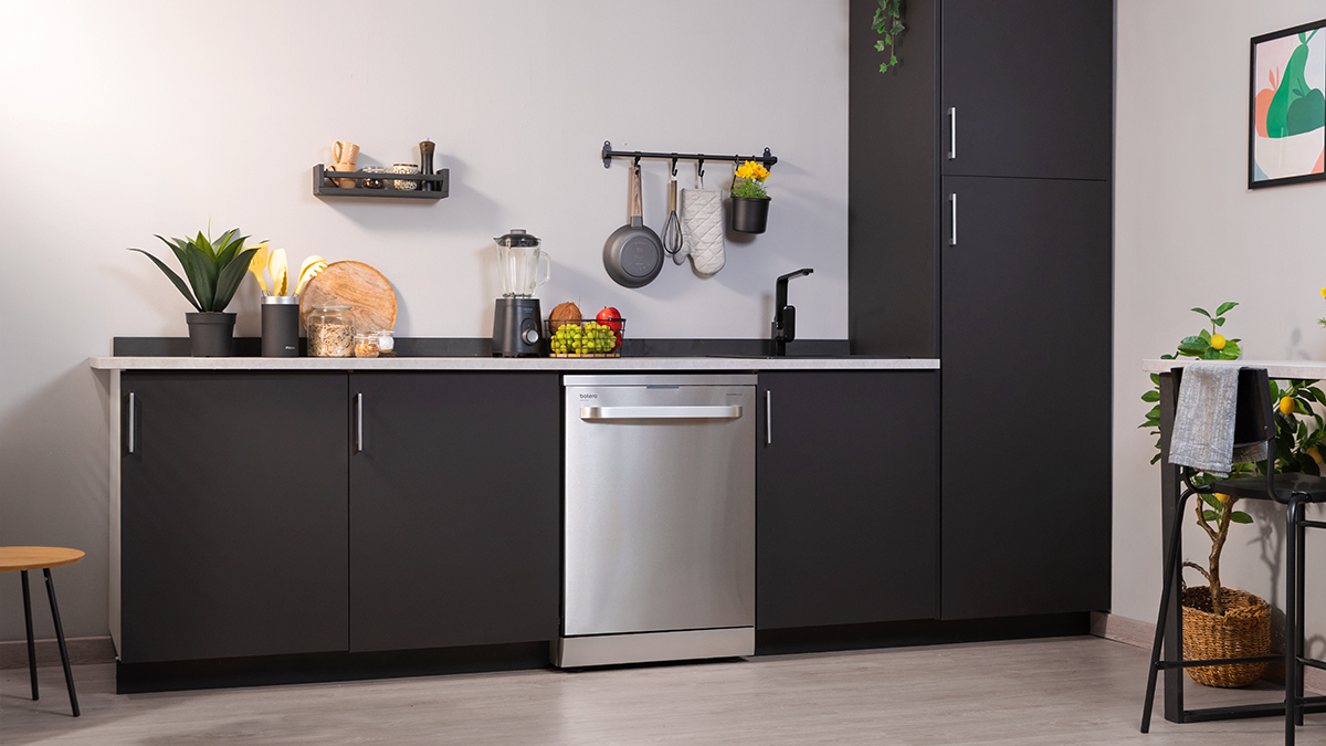 Una cocina moderna con gabinetes negros, un lavavajillas y una encimera con decoración.
