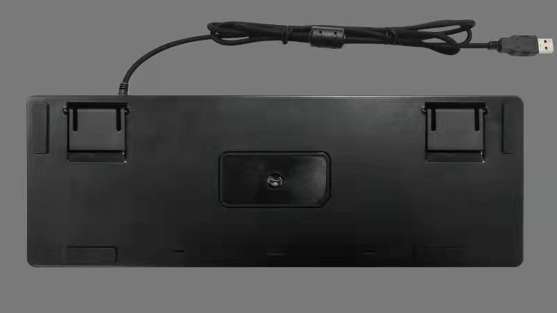 Die Unterseite einer schwarzen Tastatur mit USB-Kabel.