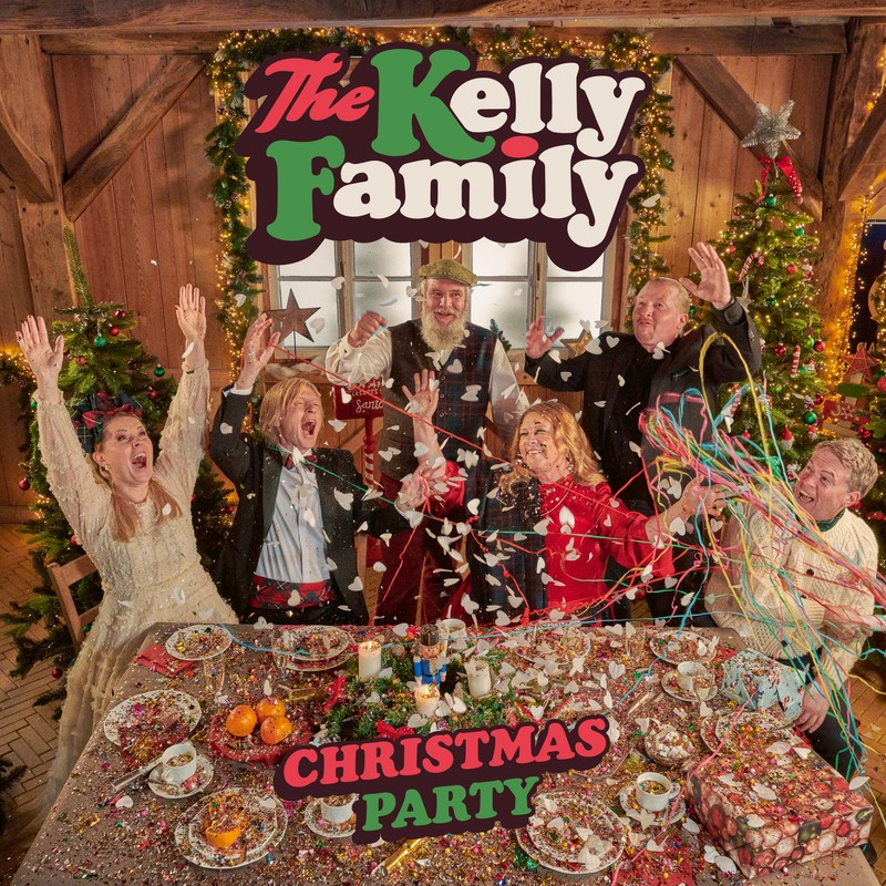 The Kelly Family Weihnachtsfeier. Leute feiern an einem Tisch mit bunten Dekorationen und einem Weihnachtsbaum.
