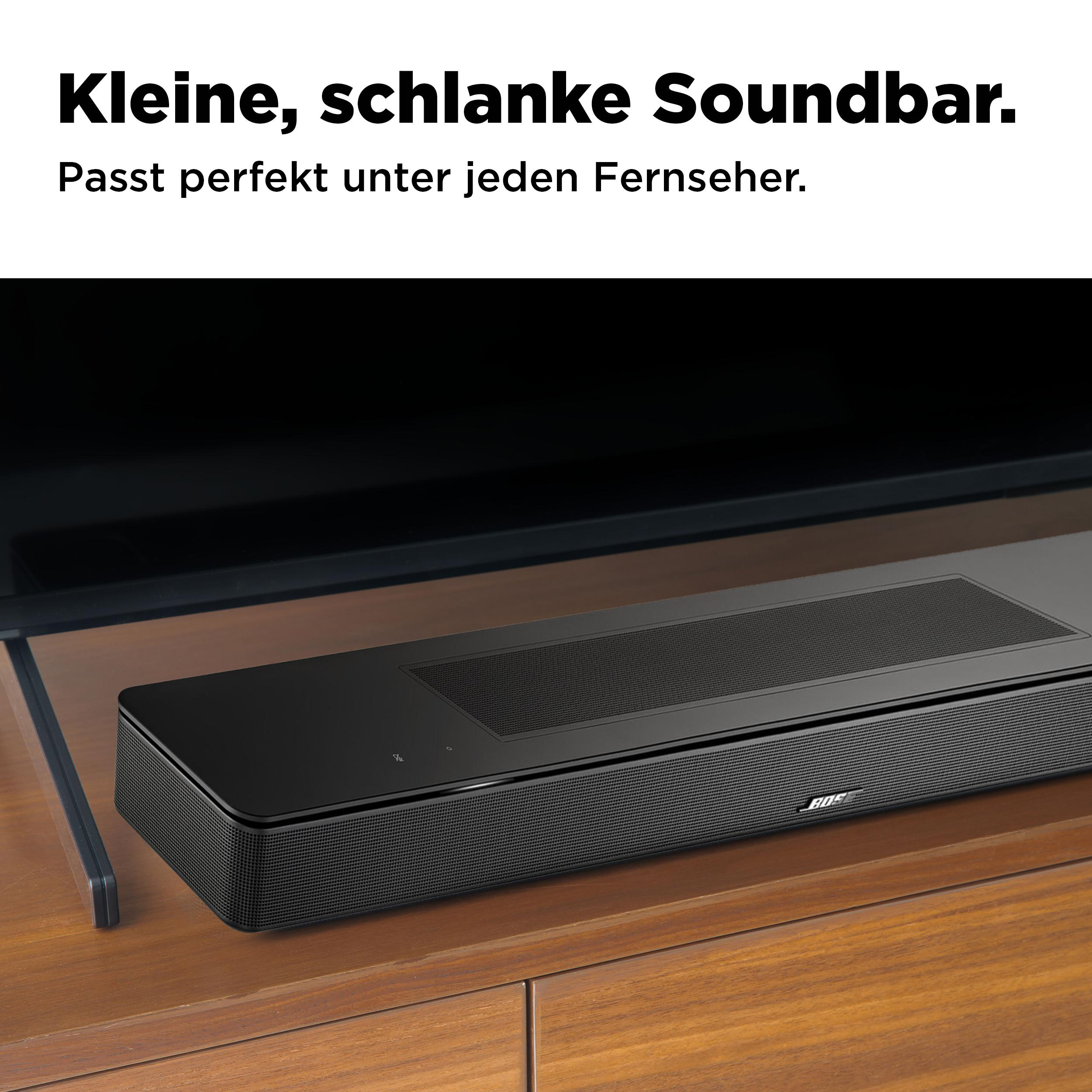 Schwarze Soundbar auf Holzschrank, unter TV.