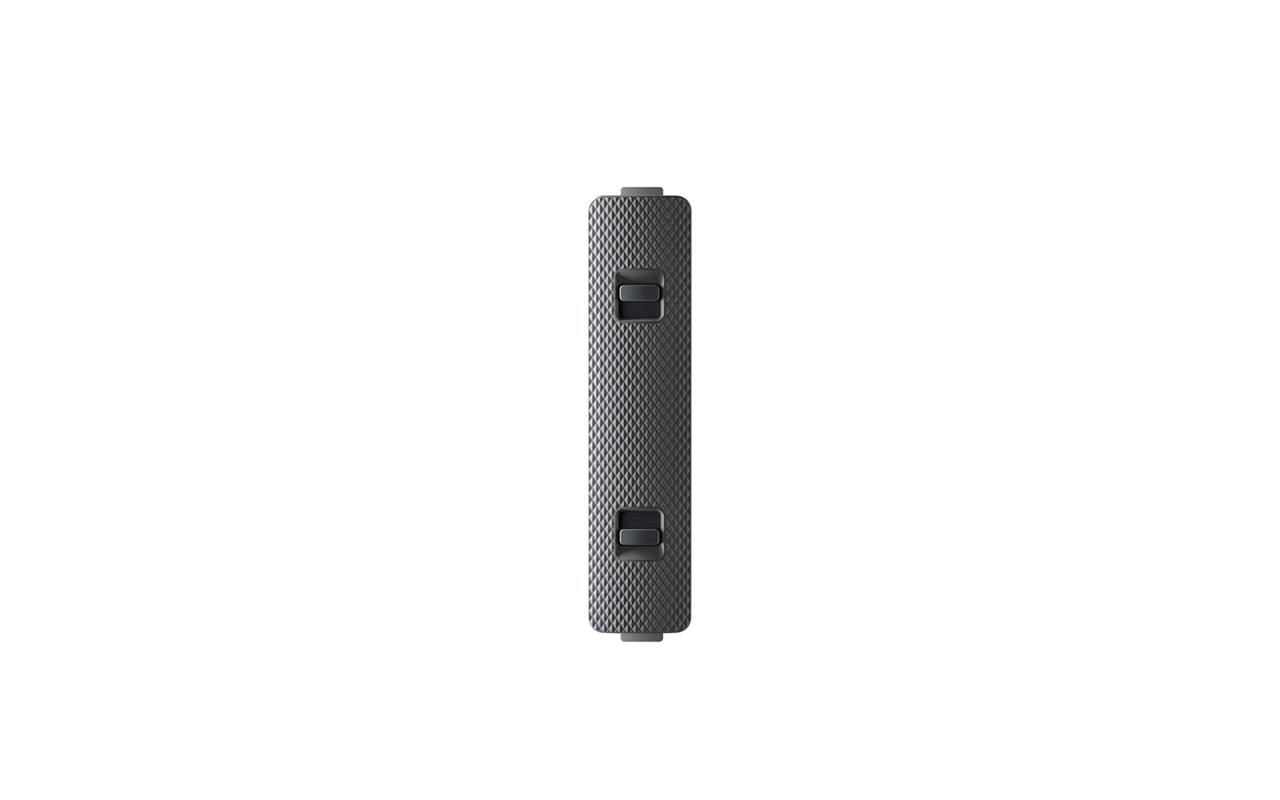Schwarzes rechteckiges Kunststoffteil mit zwei grauen Knöpfen. Scheint eine Batteriekomponente zu sein.