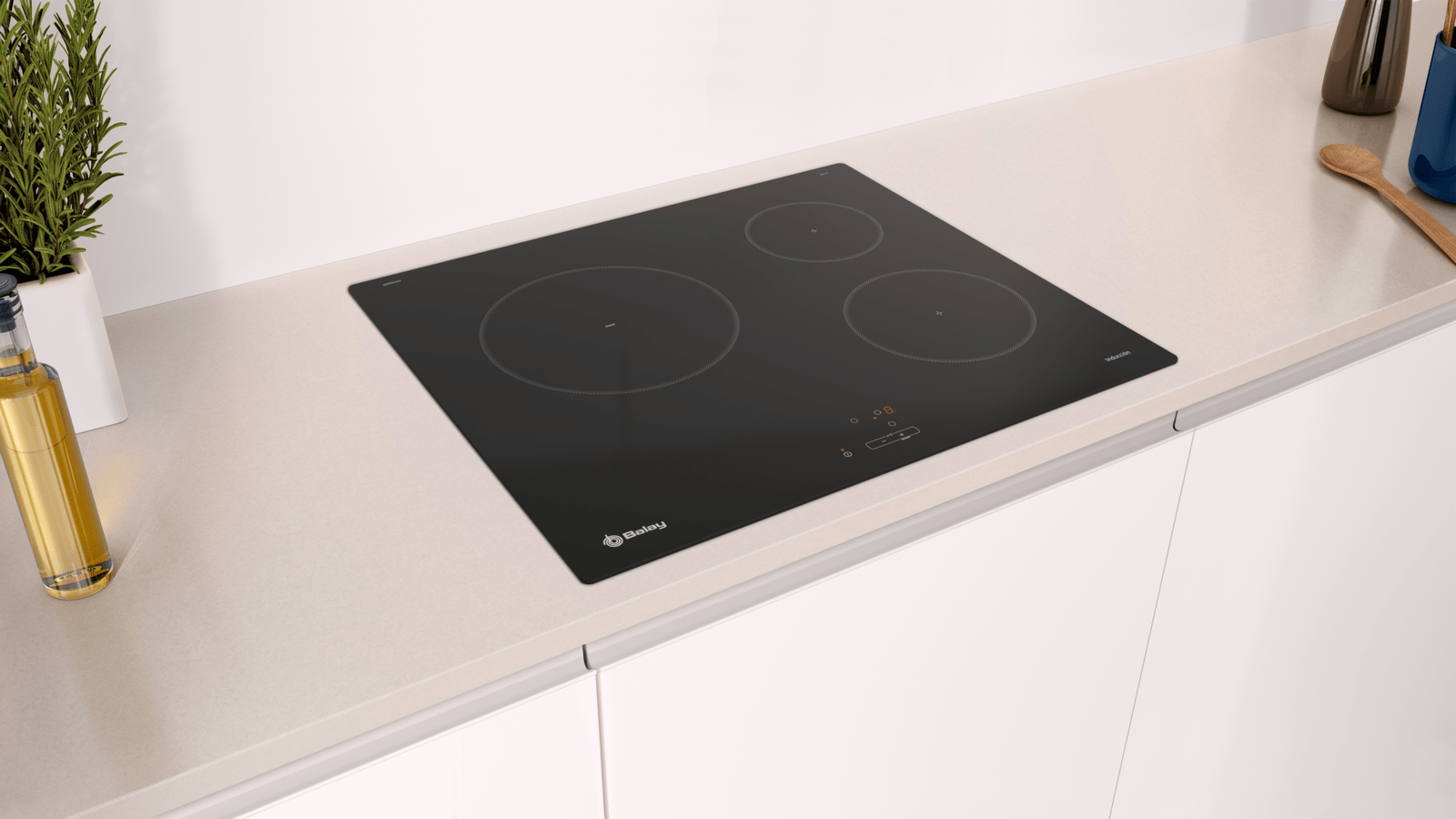 Encimera negra con tres zonas de cocción sobre encimera de cocina blanca.