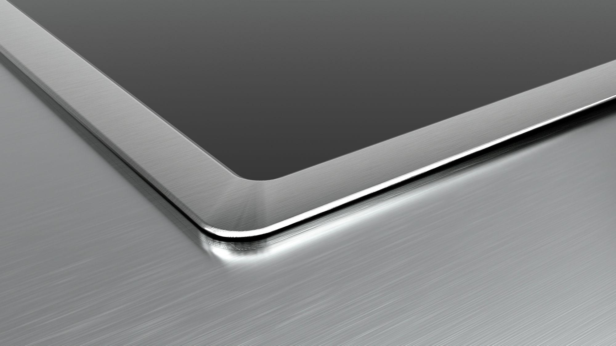 Nahaufnahme eines Tablets. Silberner Rahmen um einen schwarzen Bildschirm. Gebürstete Metalloberfläche.
