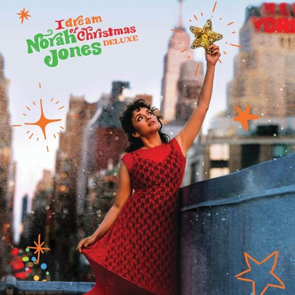 Norah Jones albumcover: vrouw met ster, stadsachtergrond, kerstthema.