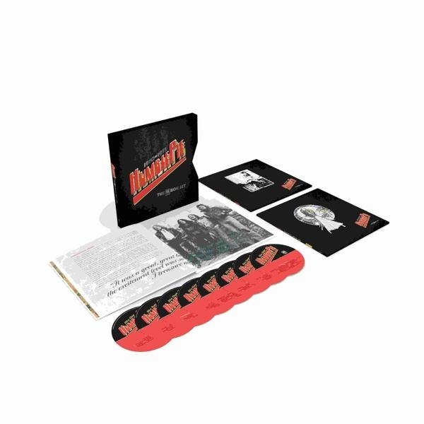 Un ensemble de disques vinyles avec des pochettes d'album et un livre, sur une surface blanche.