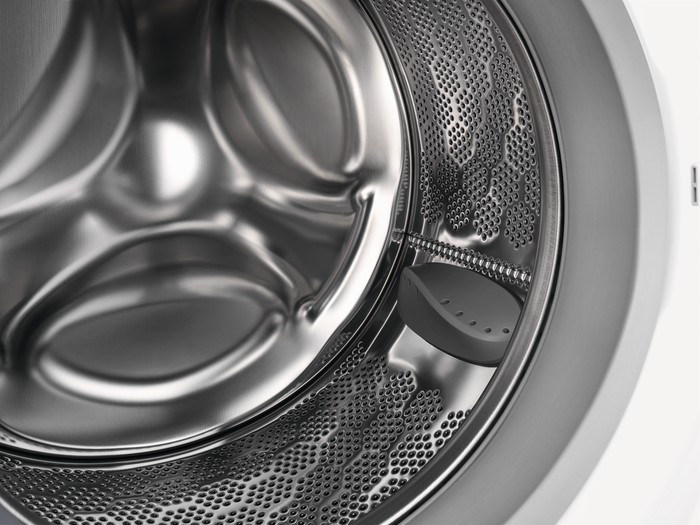 Gros plan à l'intérieur d'un tambour de machine à laver, avec un agent de lavage.